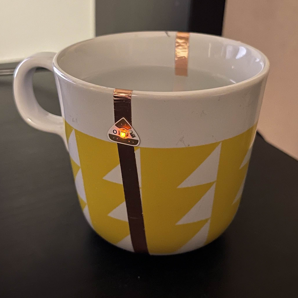 The teacup when lit from being filled with water. The battery is hidden at the bottom of the mug. 